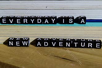Everyday is a new adventure on wooden blocks. Motivation and inspiration concept
