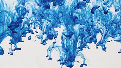 Drops of blue ink flowing from top to bottom under water.