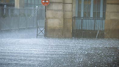 Extreme weather hail rain storm on the streets of Paris man hiding from hail