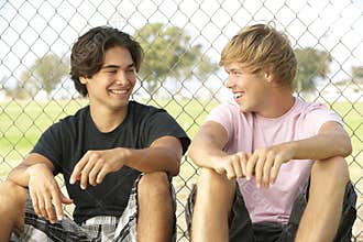 Teenage Boys Sitting In Playground