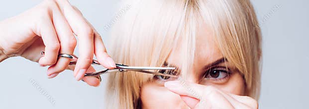 Blonde girl cut forelock. Close up hairstyle with bangs. Hair care concept.
