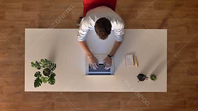 Top down shot time lapse male in wooden office using laptop while sitting at the working desk , day start and finish