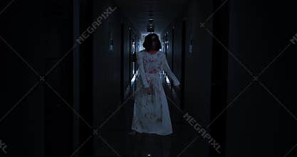 Creepy zombie woman walks in hospital corridor