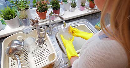 Girl Washing Dishes at Home