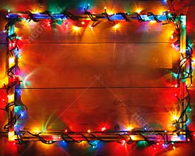 Christmas lights frame on wooden background