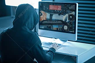 Strange man in a hood playing computer games