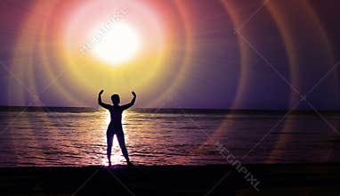 A female figure in the light of the cosmic glow of a star above the night coast.