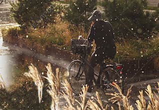 Woman cycling in rain with rainwear - rain drops falling heavy