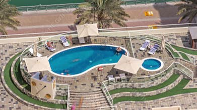 Rooftop swimming pool viewed from above timelapse, Aerial top view at Dubai marina.