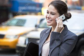 Young Woman Talking on Cell Phone by Yellow Taxi
