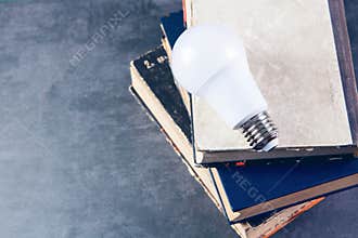 Light bulb on books on table