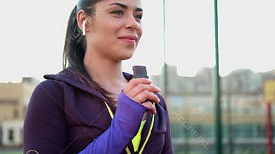 A young female athlete eats a protein bar. Sports nutrition, light snack after training.