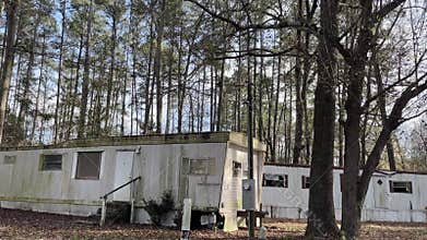 Pan of Run down trailer homes in a trailer park on Durano park trail busted windows