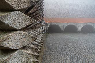 Original granite faÃ§ade of the bell tower of the Sanctuary of Aranzazu under the fog.