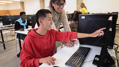 Young Asian student with teacher during university lesson in classroom