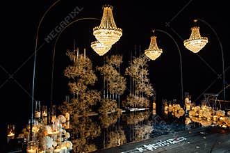 candle light in glass lanterns and gorgeous lamp at luxury wedding ceremony in evening, decor and arrangements