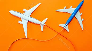 Two passenger aircraft in flight on a beautiful orange background top view, aircraft flying with a contrail, copy space. Airline