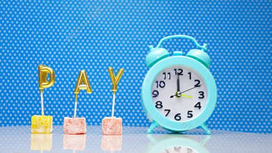 Word day with a retro clock on the arrow 12 on a blue background, the word day from the letters with a clock display.