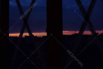 Taped windows crosswise during war to avoid bomb damage. The night cityscape through the glass. Conceptual. War, death