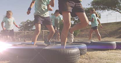 Animation of light spots over diverse schoolchildren exercising on obstacle course