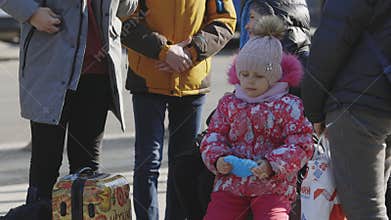 Lviv, Ukraine - March 15, 2022: Portrait of little girl standing at the street. Evacuees from eastern Ukraine near the