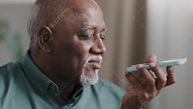 Mature grey-haired 60s biracial man with beard african american senior old male at home hold smartphone speak to phone