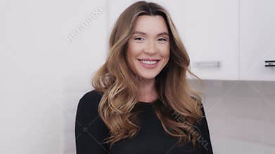 Home portrait of a shy smiling woman with dark blond hair