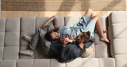 Above view on comfortable couch lying couple in love