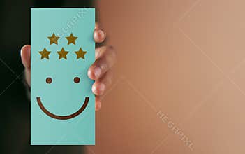 Customer Experience Concept. Happy Client giving Positive Review on Paper Card. Feedback a Happy Face Icon and Five Star Rating .