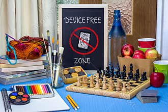 Device Free Zone chalk board on table with games, art materials, books and chess board
