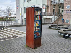 Heiligenhaus, Germany - December 2020: Selective focus of a Street box with books. Free public street library. Rusty bookcase