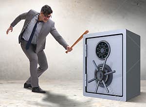 Angry man with baseball bat hitting money safe