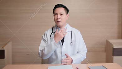 Asian male doctor look at camera online video call remote talking to patient