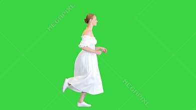 Young woman in white dress running on a Green Screen, Chroma Key.