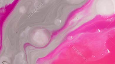 Close-up of watercolor white and pink vibrant oil paints blend together