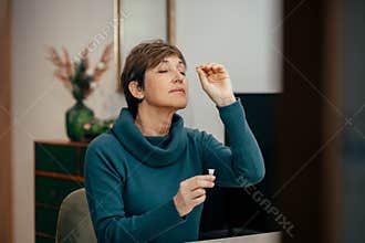 Senior woman using an nasal swab for covid 19 detection, self testing