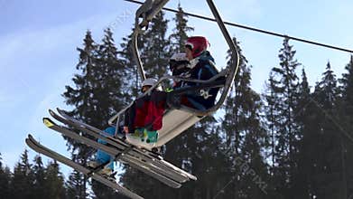 Bukovel, Ukraine - December 2020: Skiers on the chair lift moving on the mountain top at sunny day in Bukovel Ski Resort