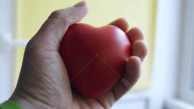 Patient human squeezes in his hand palm heart shape - carpal expander close up. Video for visualization of the heart beats, sp