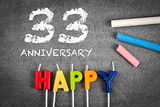 33 year anniversary. Candles and colored crayons on a dark chalk board