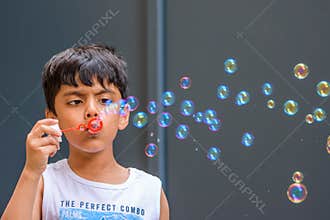 A child blowing soap bubbles; casual portrait