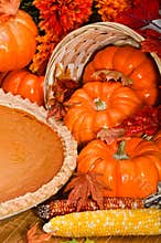 Pumpkin pie with autumn leaves and pumpkins.