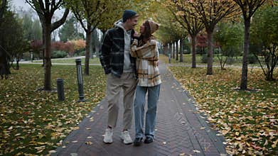 Happy couple in love having romantic walk with joy and fun in foliage park.