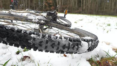 Rear mtb wheel with fat tire for extreme terrain. Close up of a tire of the bicycle. The bike in the winter snow place.