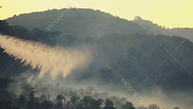 Fire fighting helicopter is dropping water on forest fire