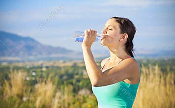 Fitness woman drinking water after workout