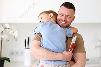 Little boy son giving dad greeting postcard with drawn red heart on Fathers Day