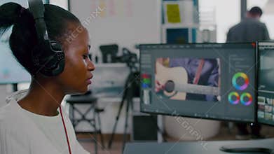 African woman videographer with headphones editing video footage