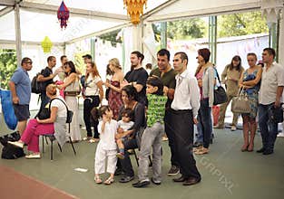 Group Asian children and adults standing under tent and listening to huru preaching
