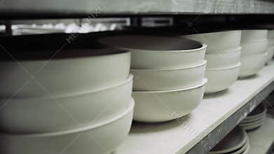 Molds for ceramic dishes are on the shelves of production and ceramics harden in them.
