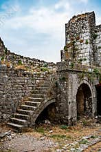Fragment of a stone wall with arched holes and a staircase in Shkoder Castle Albania. Ruins of a medieval European defensive